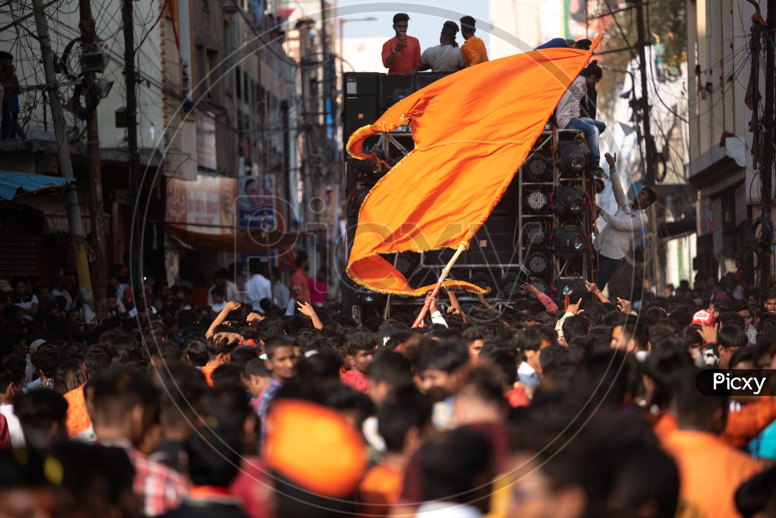 A man holding a Saffron flag in a crowd at Shri Rama Shobha yatra in Hyderabad