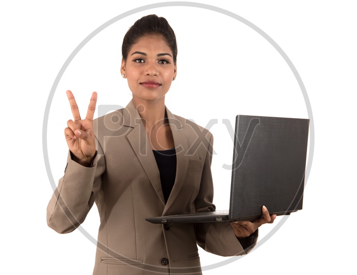 Young Indian business woman holding a laptop making peace sign