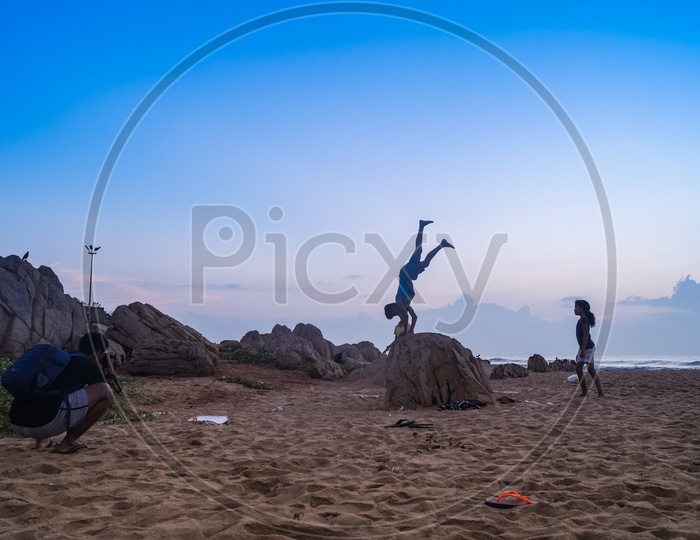 A Photographer Taking The Pictures Of a  Children Doing Gymnastics in Beach