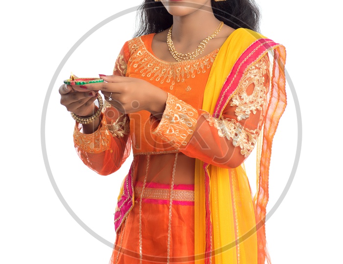 A young traditional pretty Indian woman holding diya in hand