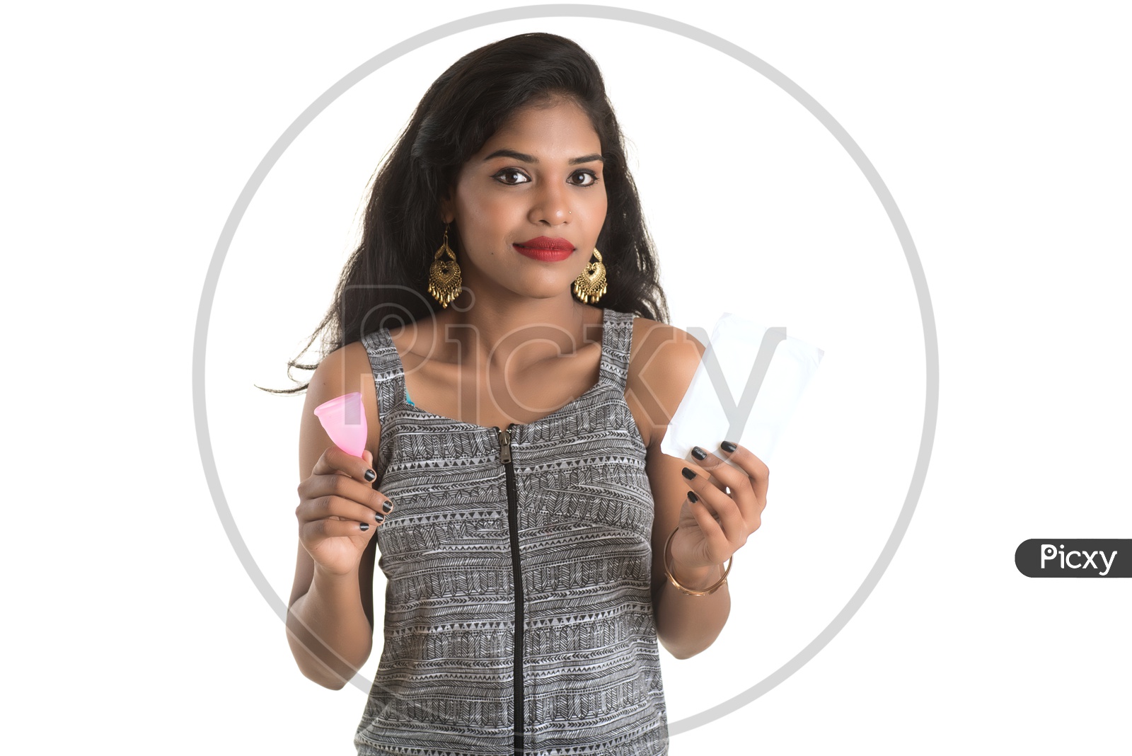 Indian woman holding a menstrual cup and sanitary napkins