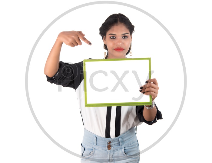 Pretty Young Indian girl Holding Blank Placard and Pointing Empty Space On an White Background
