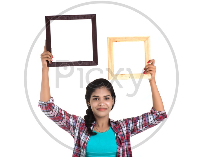 Attractive Young Woman Holding Picture Frames and Posing On White Background