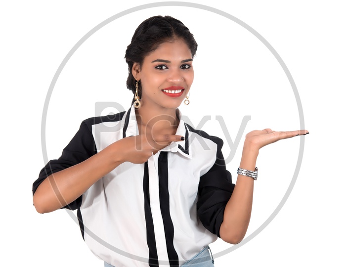 Young Beautiful Girl Holding Something In Hands  and Showing Space  With  a Smile Face Over an Isolated White Background