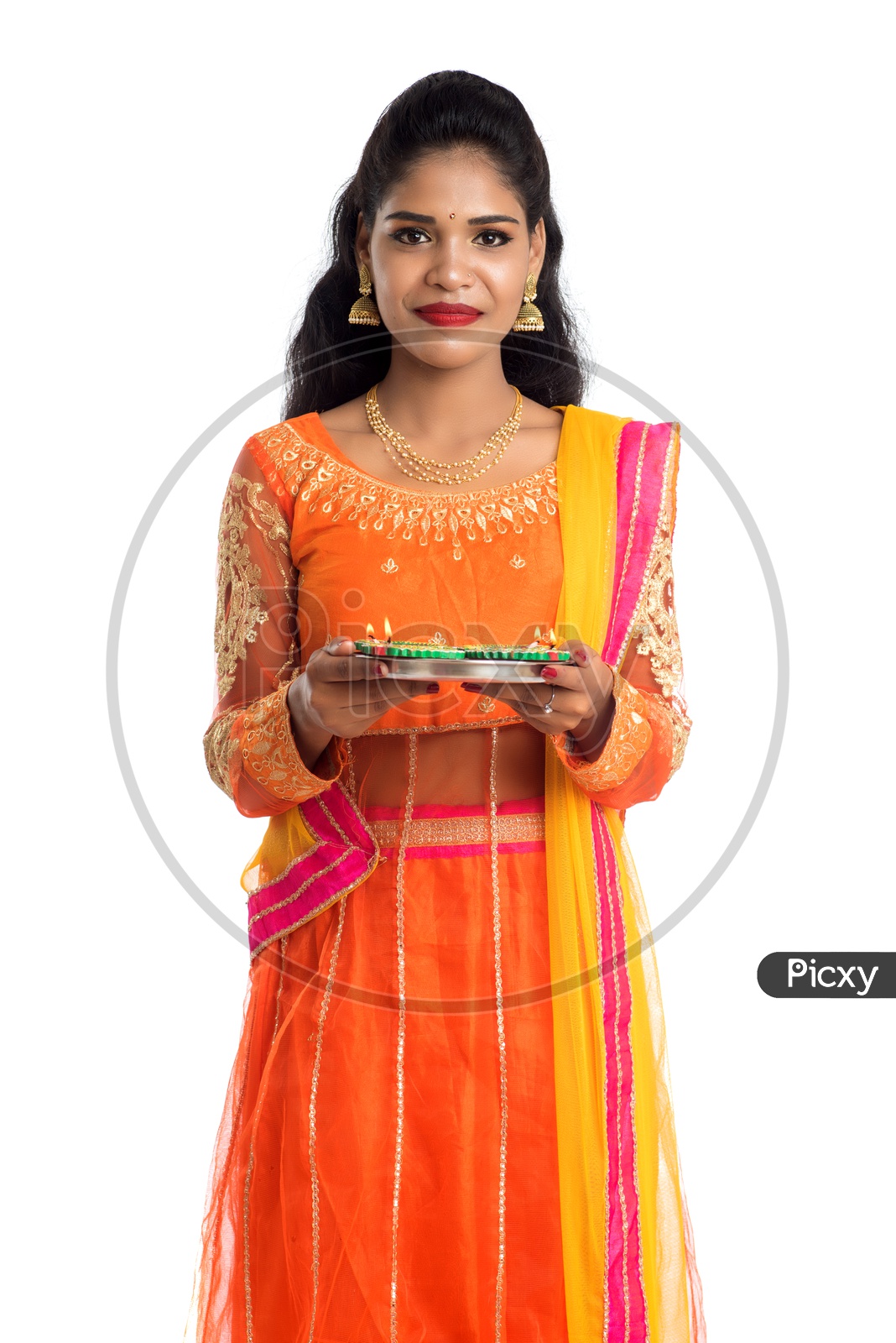 A young traditional smiling Indian woman holding Diyas in hand