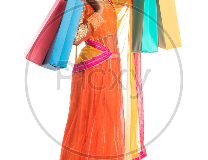 Young Indian Traditional  Girl Holding Shopping Bags Or Festival Shopping Bags And Posing On an Isolated White Background