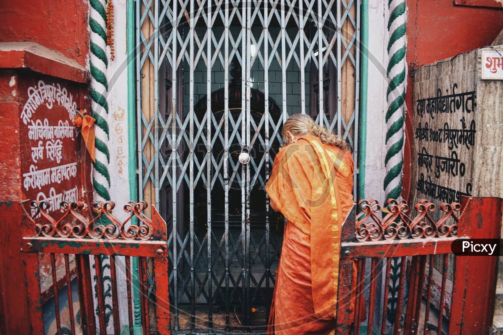 An Old Woman Devotee Offering Prayers To God In Hindu Temple