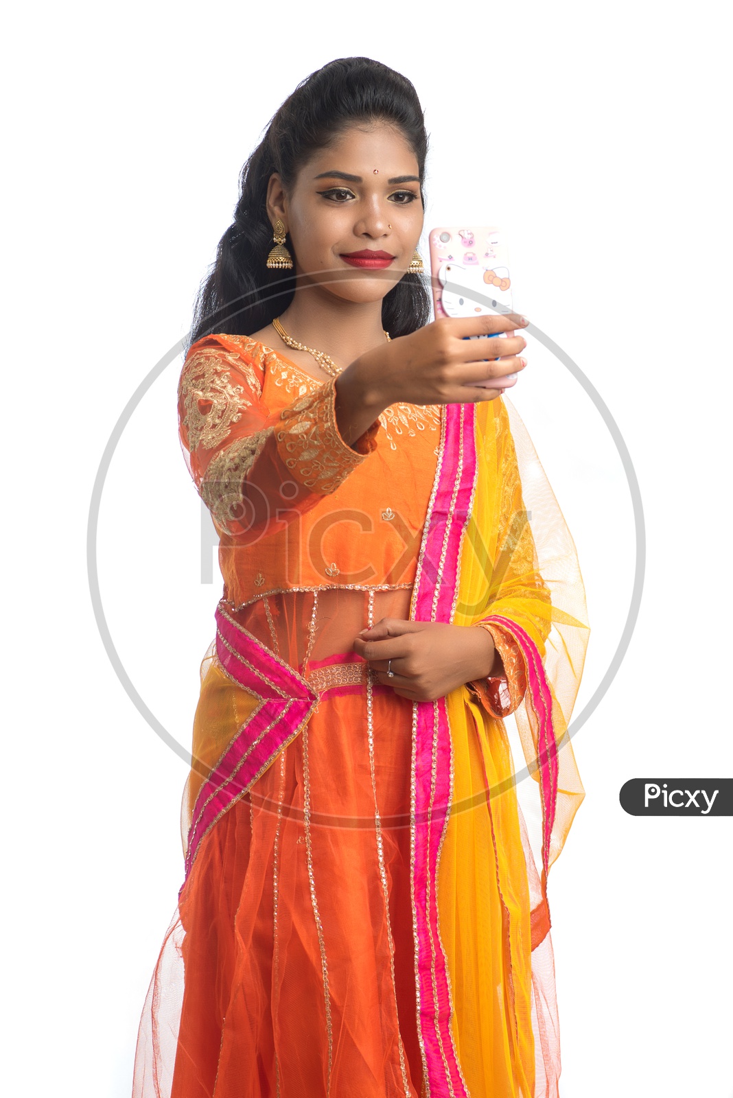 A Young traditional Indian girl Taking a Selfie With Smart Phone on a White Isolated Background