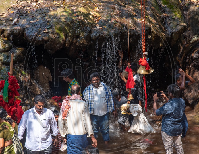 Devotees near a waterfall at Gubbala Mangamma Thalli Temple