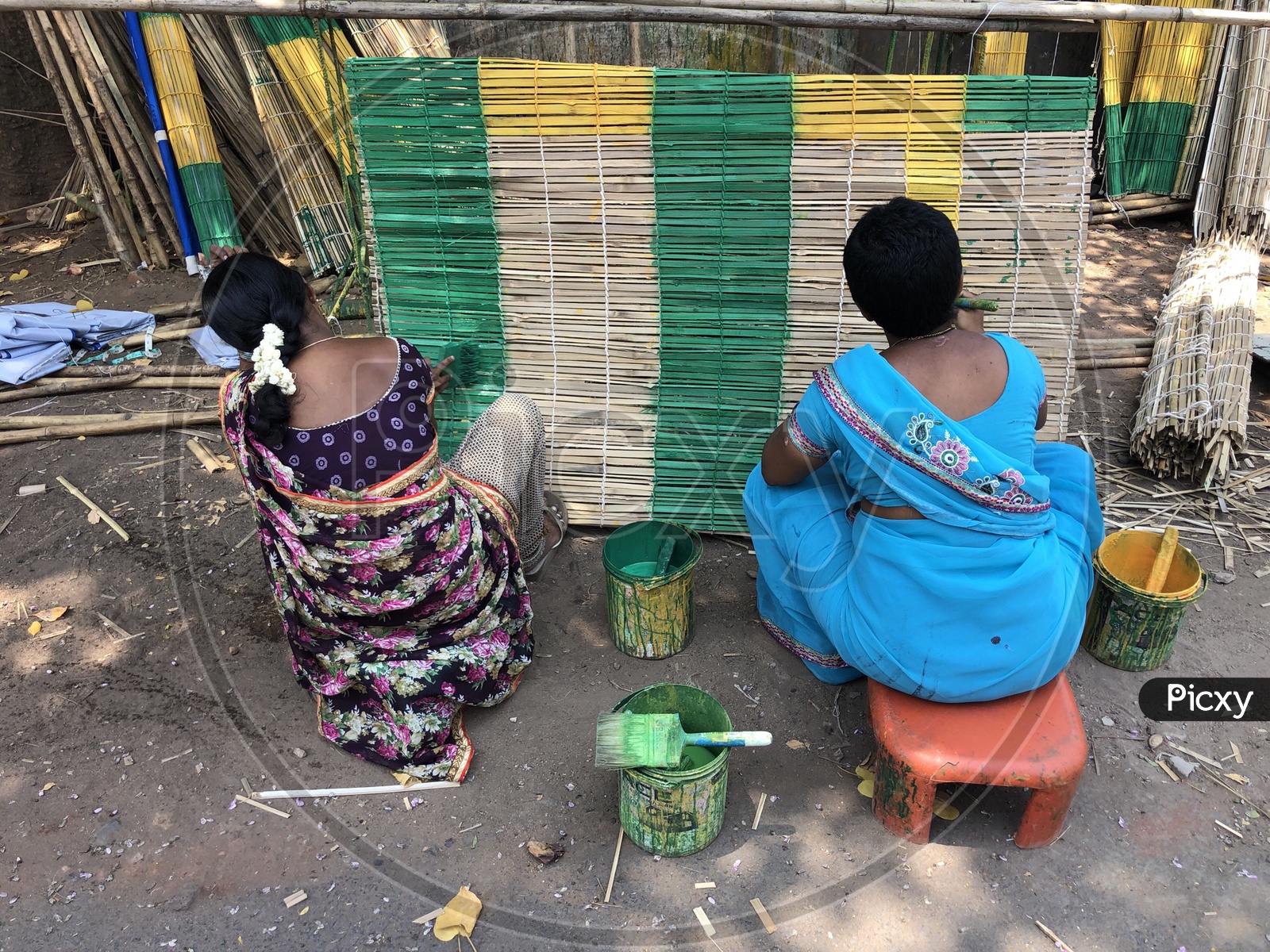 Indian Women painting the bamboo shade