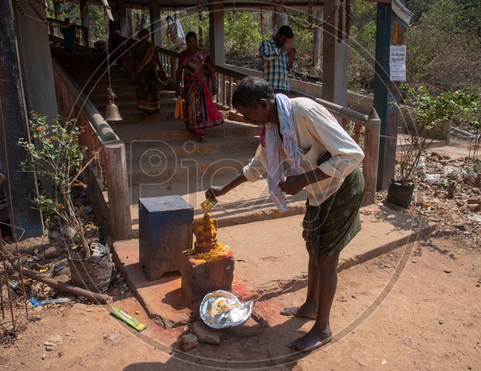 A man worshipping a Hindu goddess Idol by offering turmeric powder at Gubbala Mangamma Thalli Temple