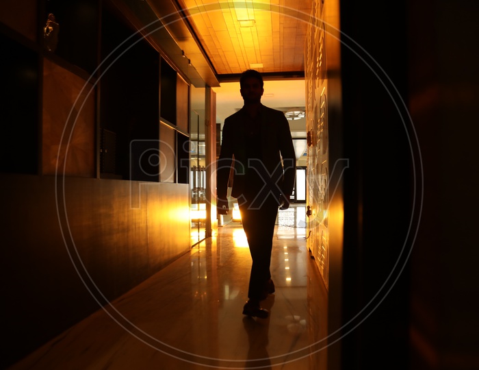 Silhouette of a Man Walking In a Corridor