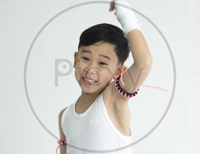 A Young Thai Child Boxer Wearing Boxing Gloves And Posing