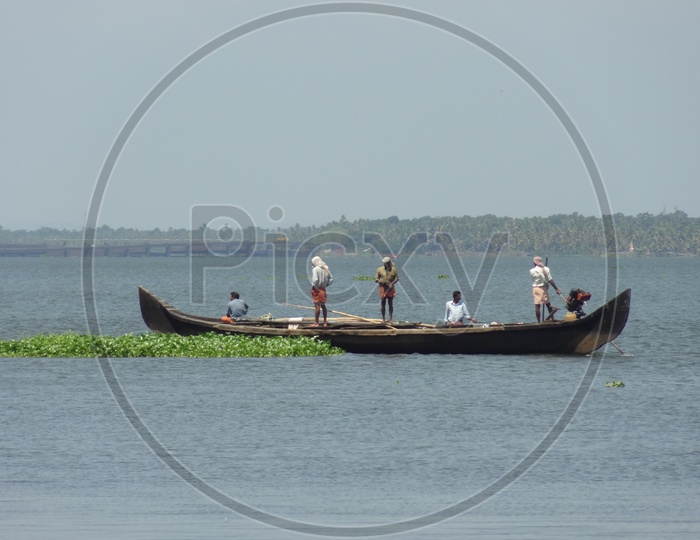 Fishermen in a small boat in Kerala backwater on a sunny day