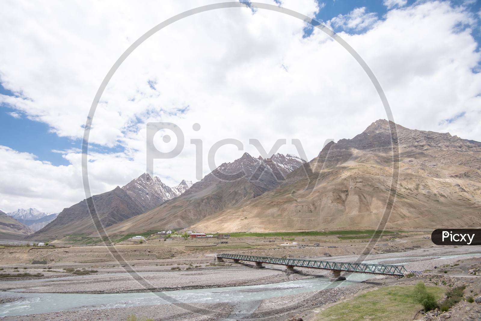 Snow Capped Mountains of Spiti Valley with water flow in the foreground