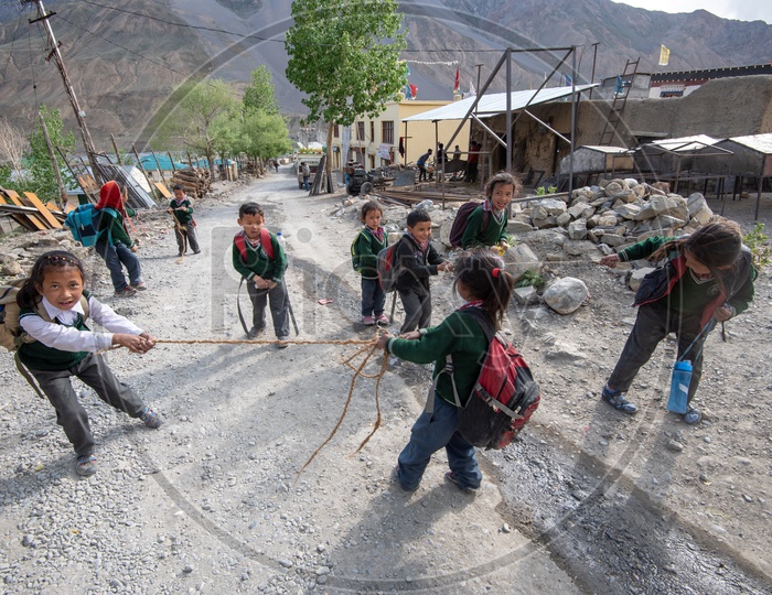 School children playing with rope on the road in Spiti Valley