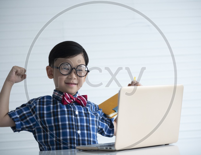 A Young Thai Boy or Child Student With a Laptop and With a Expression on Face
