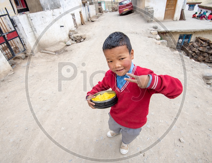 A school boy with his lunch box in Spiti Valley