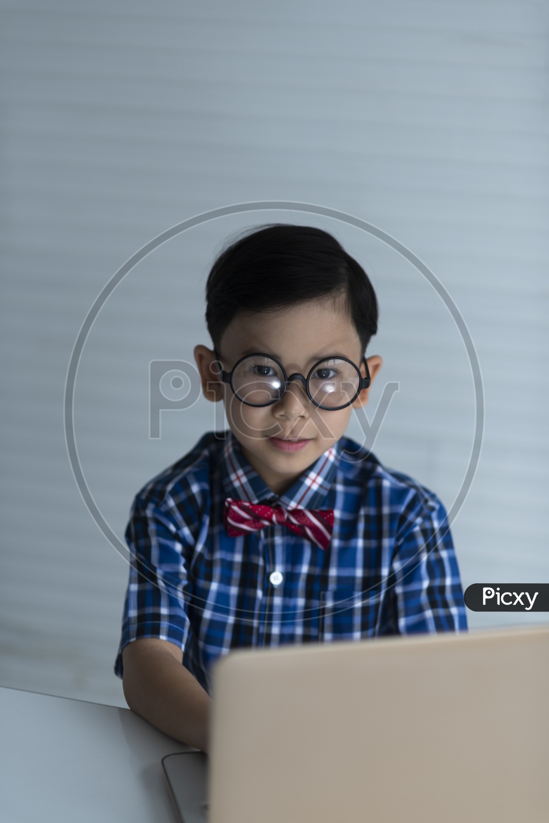 A Young Decent Thai Boy Or Child Student With A Laptop On Study Table And Posing