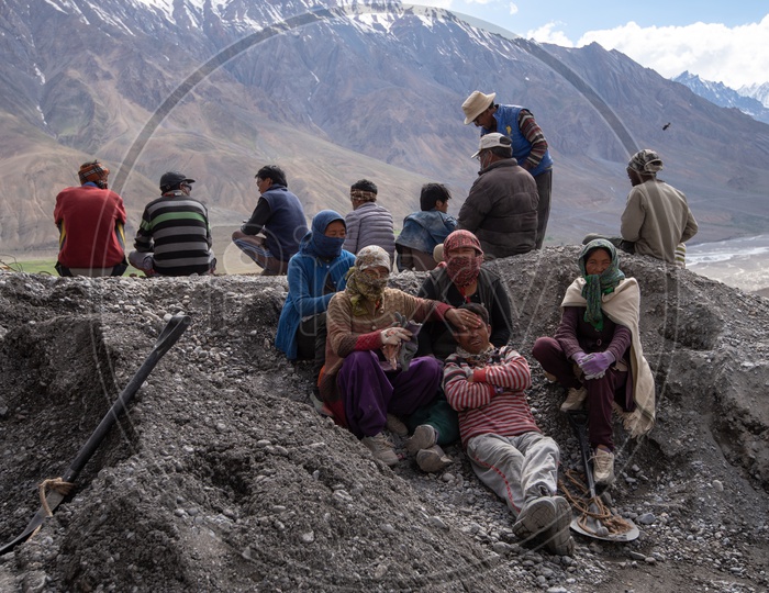 People at construction work in Spiti Valley with Snow capped Mountains in background