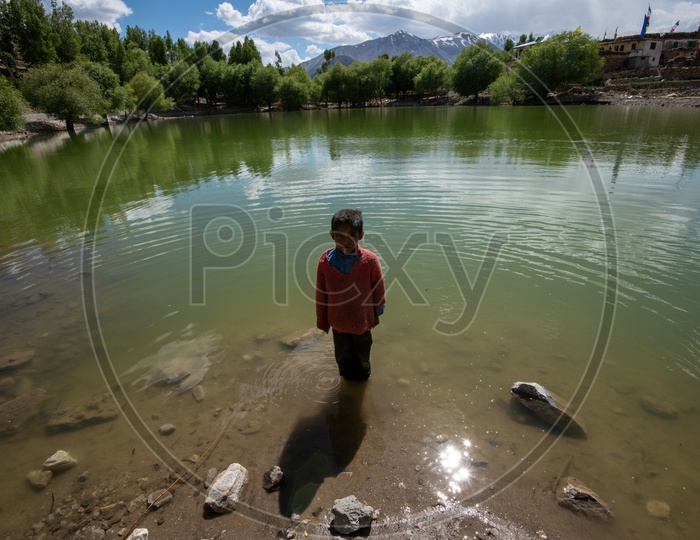 Portrait Of a Young Boy Or Child  Standing At a Lake In Leh Villages
