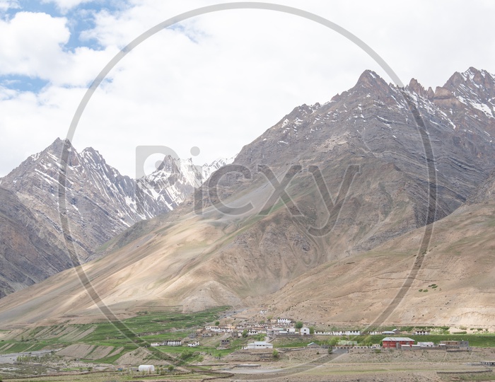 Agricultural farm lands and houses beside Spiti river with snow clad mountains in the background in Spiti Valley