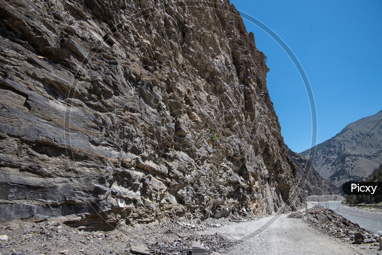 Narrow mountain road beside the river stream in Spiti Valley