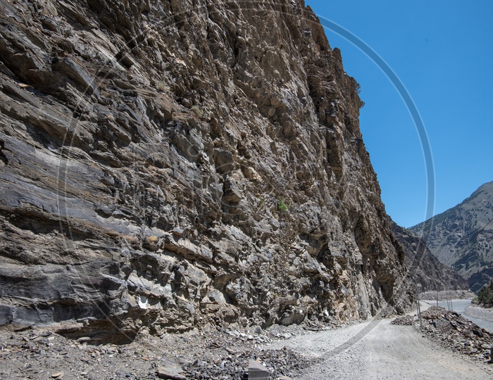 Narrow mountain road beside the river stream in Spiti Valley