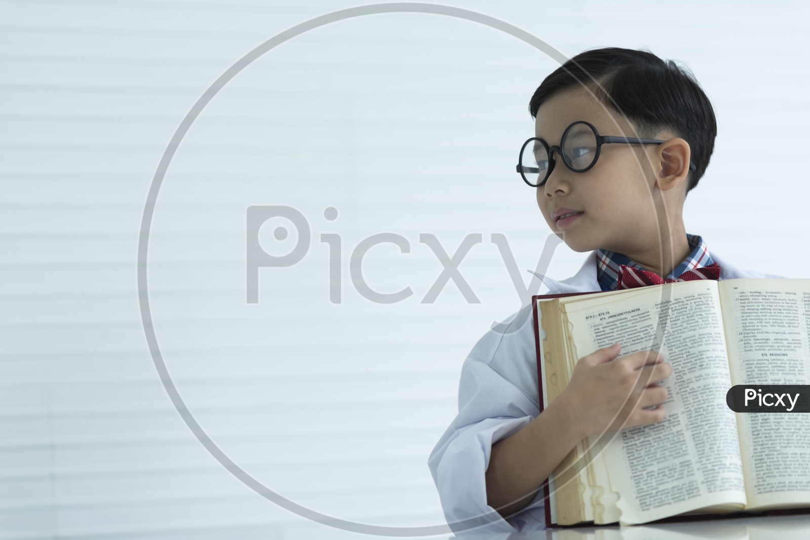 A Young Thai Boy Refering Books Wearing a White Apron In a Chemical Research Lab