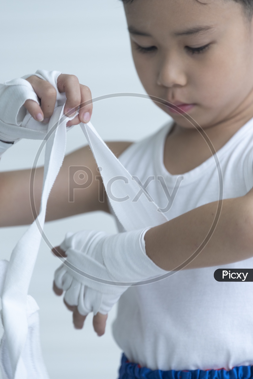 A Young Thai Boy  Boxer Wrapping His Hand For Boxing