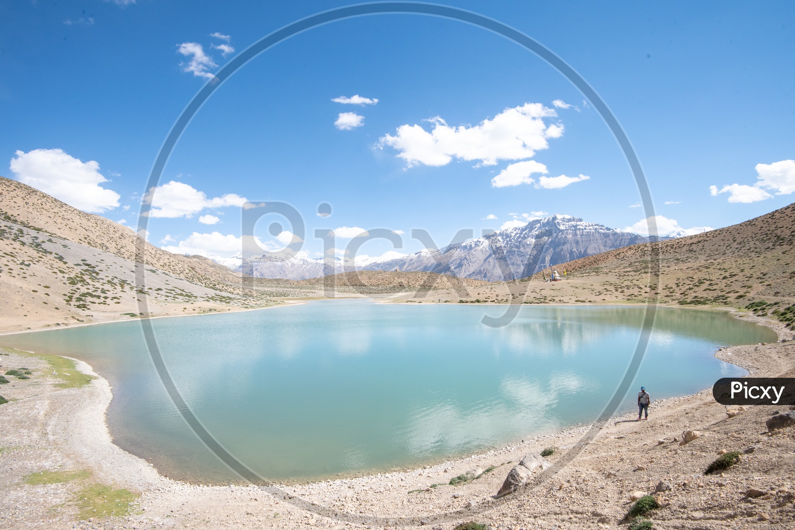 Tourist at Dhankar lake with mountain peaks in the background