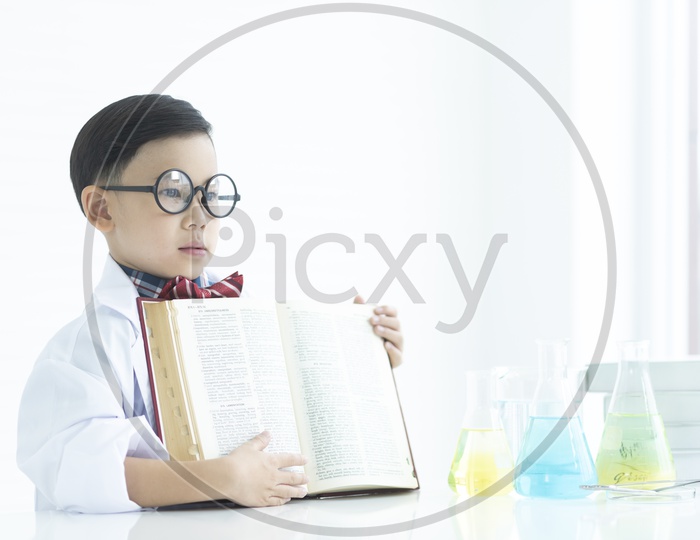 A  Young Thai boy or Child Student Making Science Experiments In Beakers At a Chemical Lab