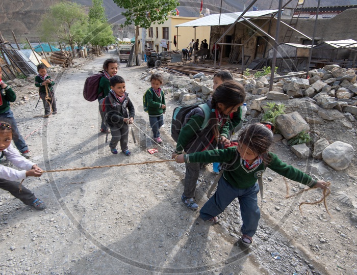 School children playing with a rope on road on the way to home in Spiti Valley