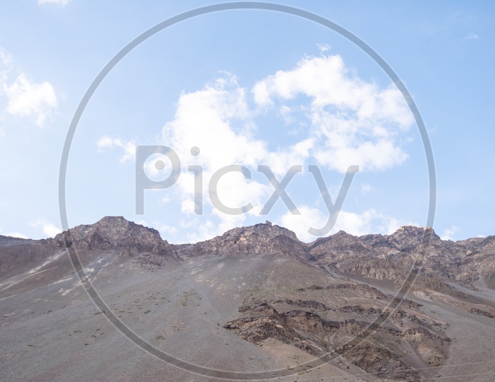 Terrain Badlands With Sedimentary Soil Dunes In Leh  and With a View Of Cotton Clouds And Blue Sky
