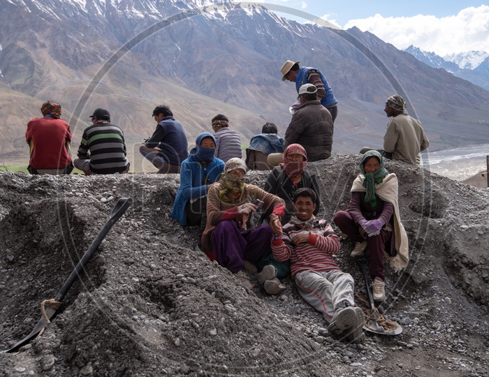 People at construction work in Spiti Valley with Snow capped Mountains in background