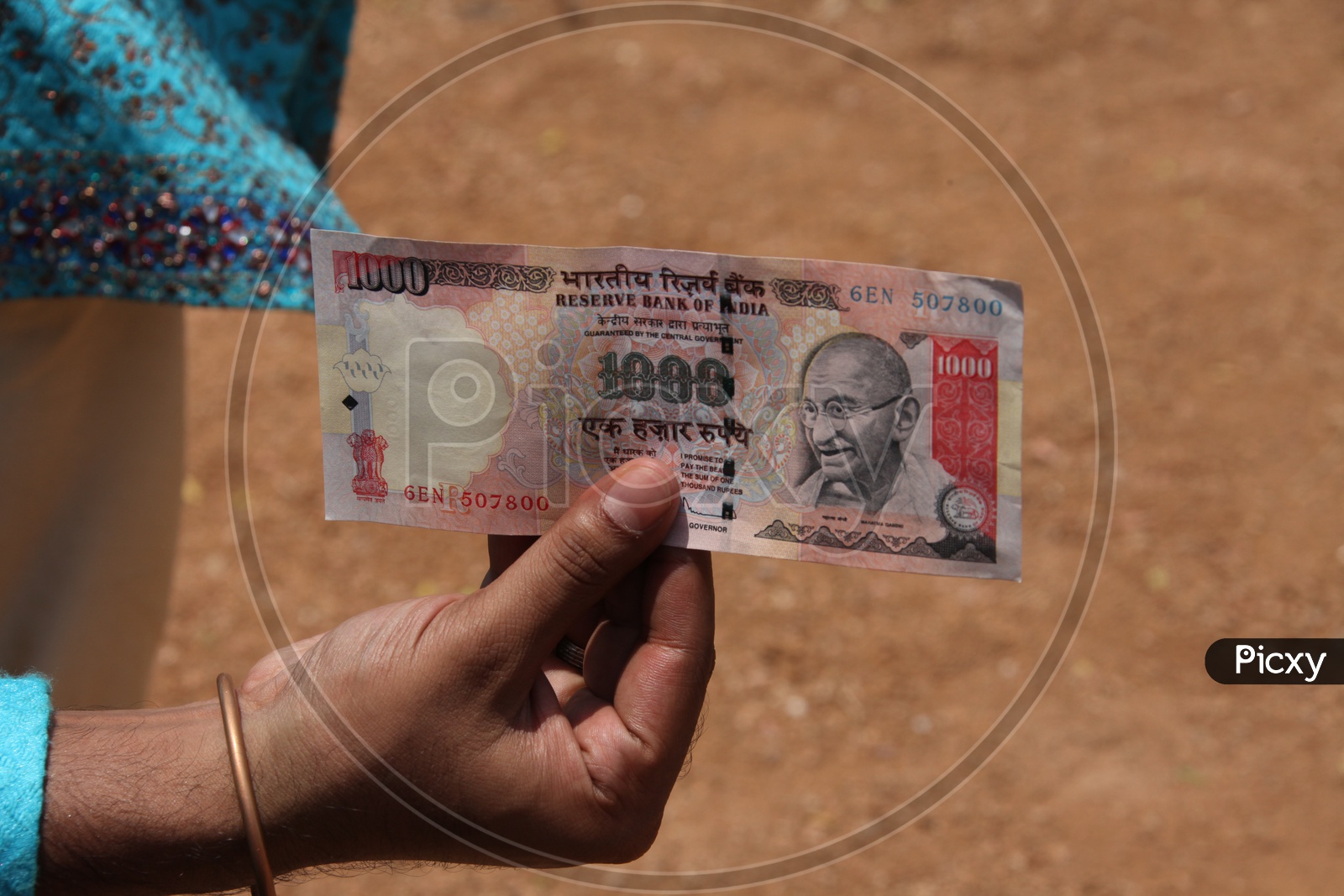 A man holding a thousand rupee bank note