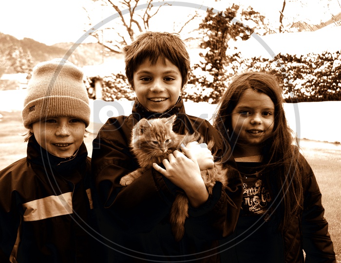 Smiling children holding a cat