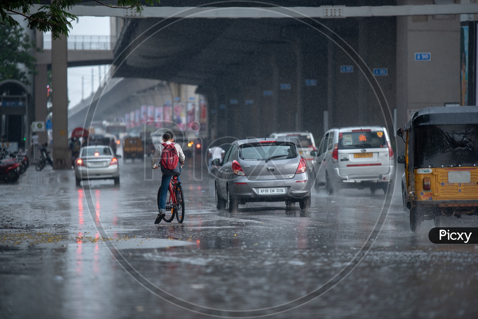 A Cyclist  on Flooded City Roads With Water Splash on a Rainy Day