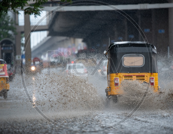 Commuting Vehicles on Flooded City Roads With Water Splash on a Rainy Day