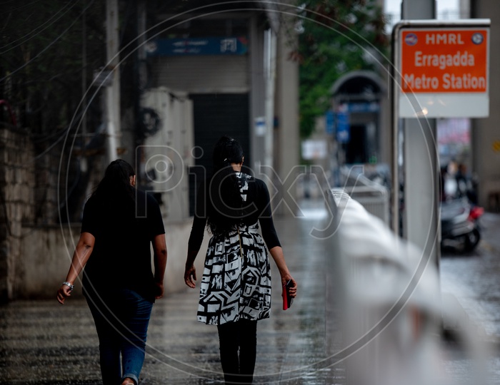A Couple of Young Indian Girls Walking On footpath At Erragadda Metro Station