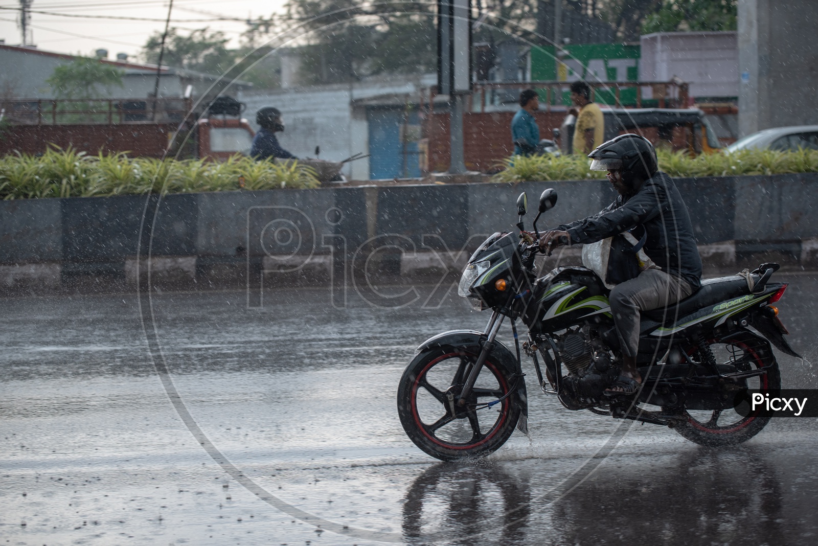 Motorcyclist Or Bikers  on Flooded City Roads With Water Splash on a Rainy Day