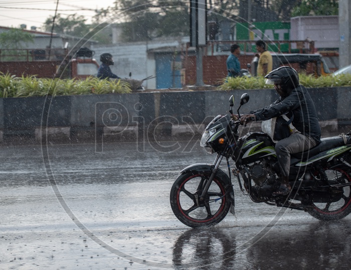 Motorcyclist Or Bikers  on Flooded City Roads With Water Splash on a Rainy Day