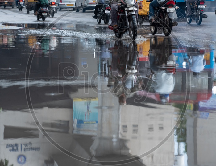Reflection of a Motorcyclist Or Bikers  on Flooded City Roads With Water Splash on a Rainy Day