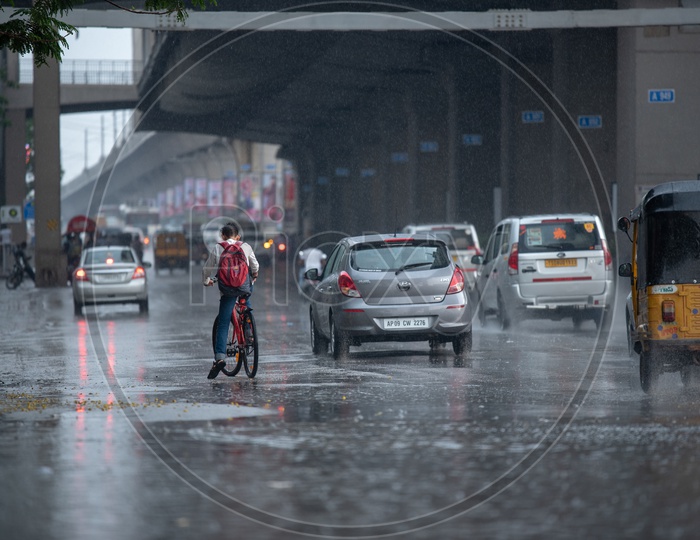 A Cyclist  on Flooded City Roads With Water Splash on a Rainy Day