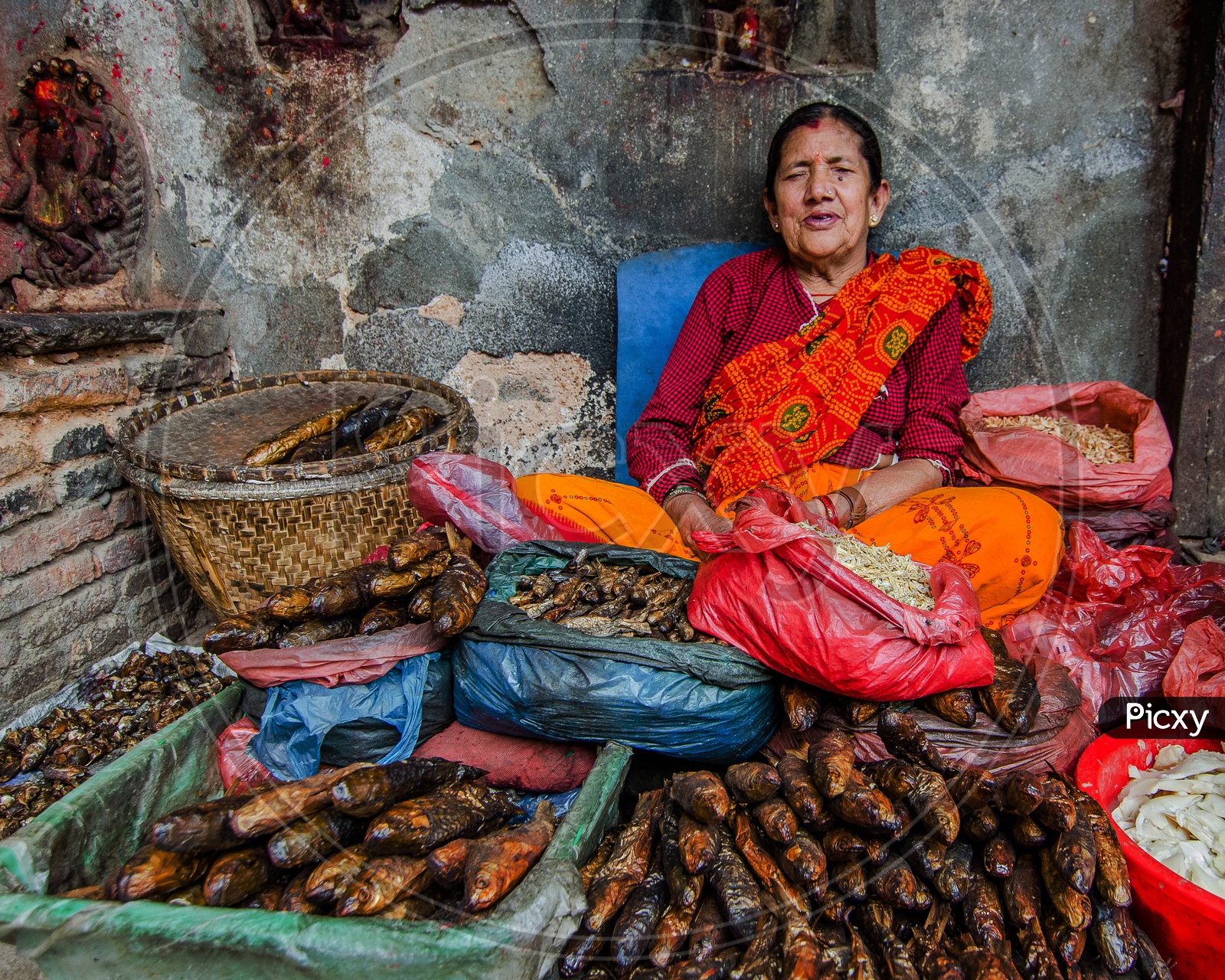A Woman Vendor Selling Dry Fish On Streets