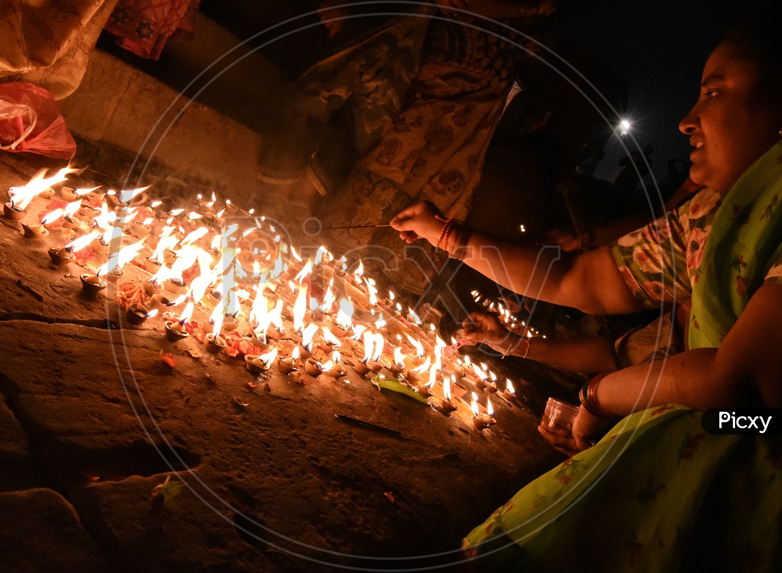 Indian Hindu  Devotees Lighting  Dias  On Festival Eve At Temple Premise