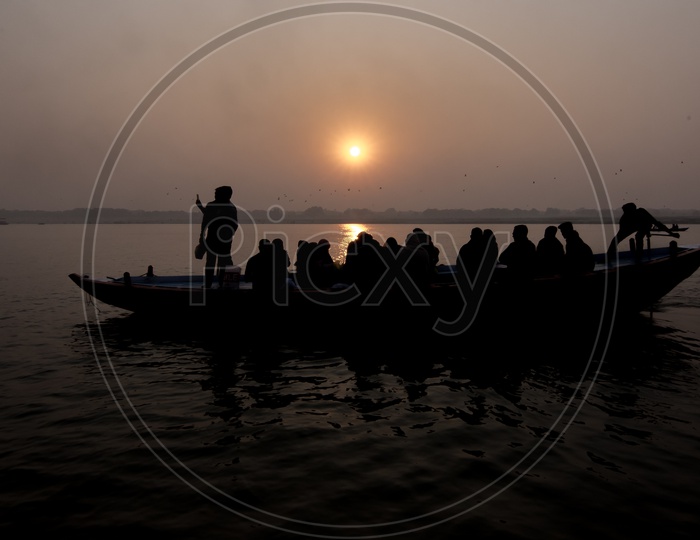 Silhouette Of a Commuting Boats and Passengers In Boat At a River