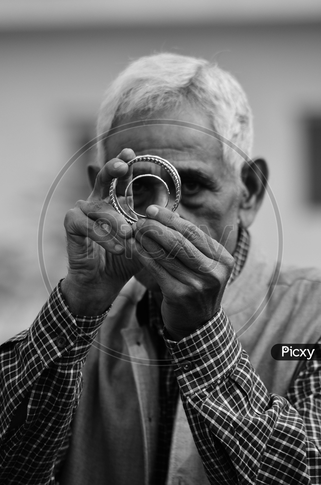 An old Indian man holding metal bangles
