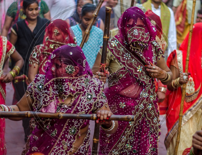 Indian Traditional Woman with Wooden Sticks In Hand in Lathmar Holi Celebrations