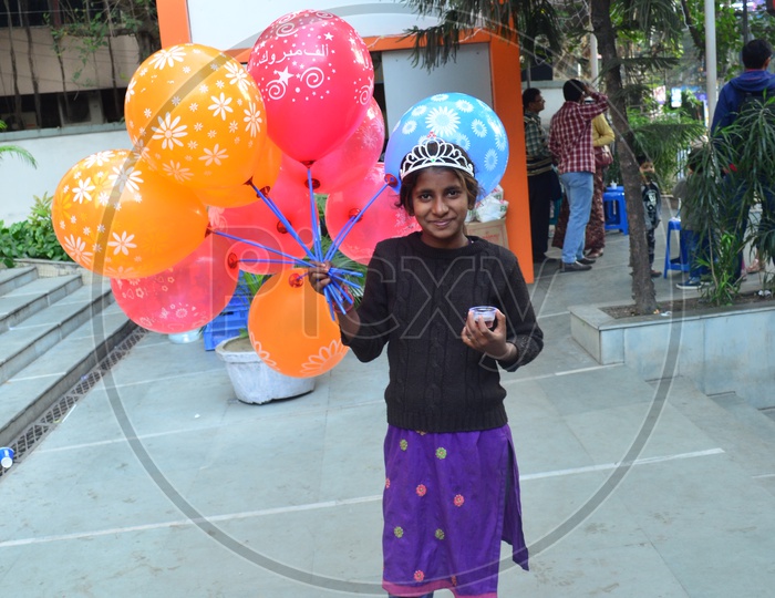 A Young Indian Girl Vendor Selling Color Balloons in a Street